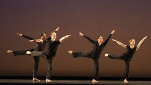 Dancers with arms and legs outstretched on stage at Zellerbach Hall