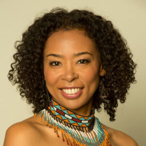 Photo of Nokuthula Ngwenyama, a young Ndebele and Japanese violinist with short curly brown hair. She wears a vibrant beaded collar-like necklace while smiling.