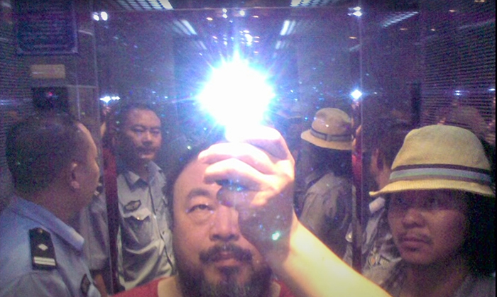 Image from Ai Weiwei's film, So Sorry, Ai Weiwei holding up a light bulb