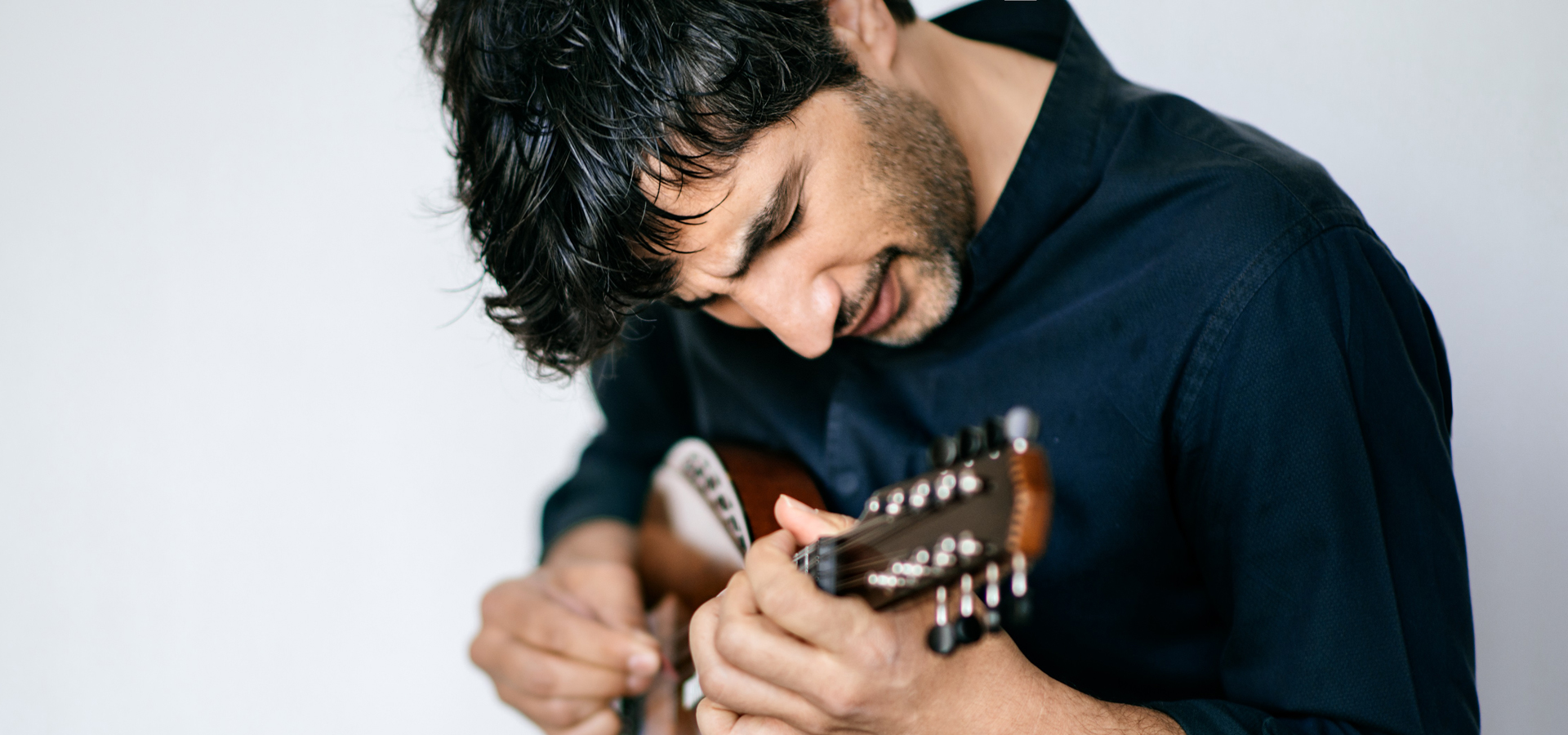 Avi Avital shown strumming his mandolin.