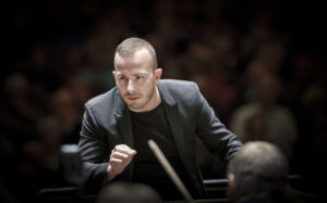 Yannick Nezet Seguin shown in action conducting the Vienna Philharmonic Orchestra.