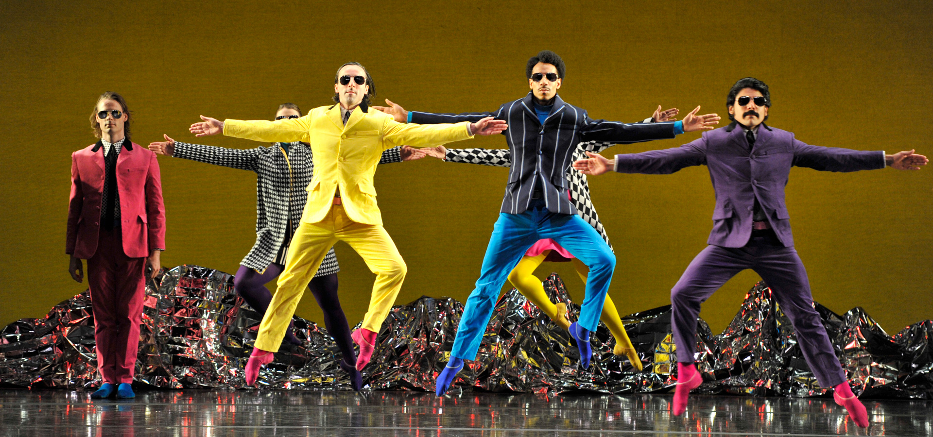Dancers performing Pepperland jump in the air with their arms extended.