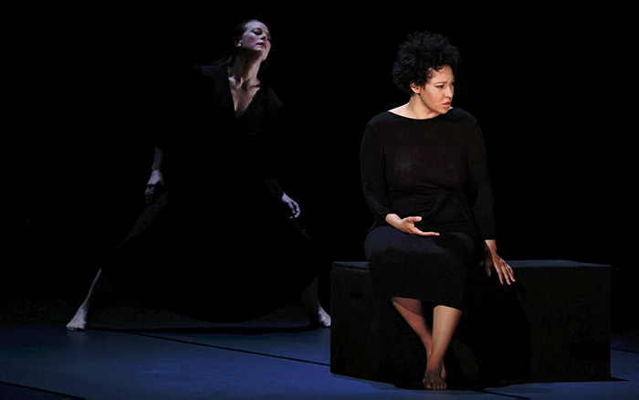 Singer Julia Bullock and pianist perform Olivier Messaien's Harawi, with two dancers on stage set against a dark background.