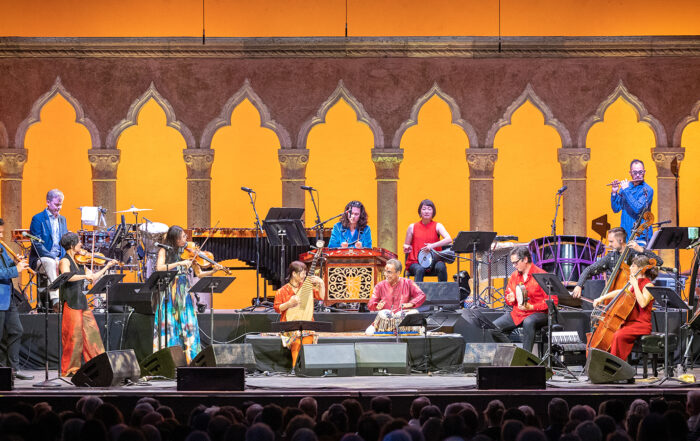 The Silkroad Ensemble performs in front of an audience in a mix of different cultural attire and instruments.