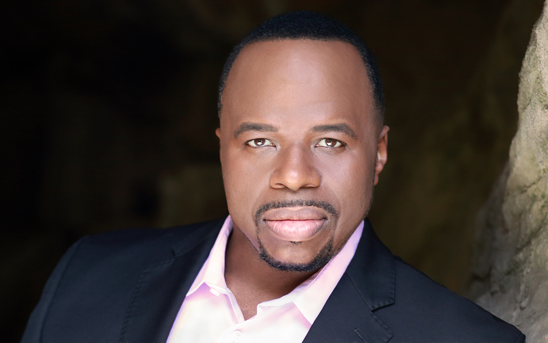 Baritone Lester Lynch, a black man wearing a dark suit and a light pink shirt looking into the camera.