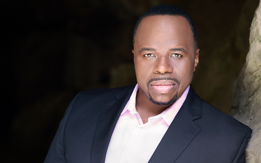 Baritone Lester Lynch, a black man wearing a dark suit and a light pink shirt looking into the camera.