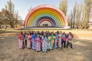 Soweto Gospel Choir in colorful costumes in rainbow amphitheater