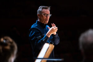 A man stands up to conduct the master chorale group in Los Angeles.