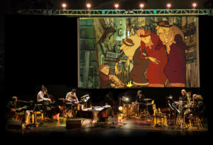 Musicians perform on stage underneath a large movie projection.