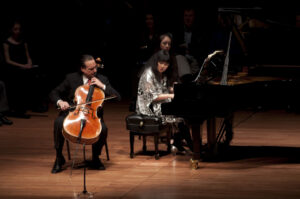 David Finckel plays the cello onstage next to Wu Han, who plays piano next to him.