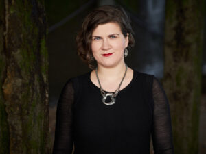 Photo of Ema Nikolvska wearing a black dress and a silver statement necklace.
