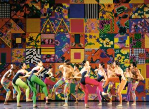 Grupo Corpo dancers wear bright leotard costumes and patterned leggings.