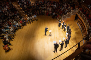 The Tallis Scholars perform in a half circle for the audience seated around them.