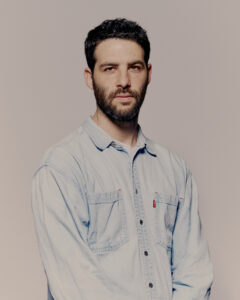 Or Schraiber wears a denim button up and looks seriously at the camera.