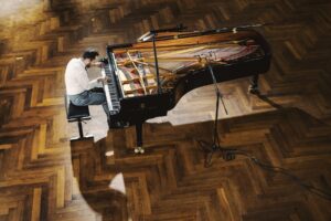Aerial photo of Igor Levit playing a grand piano.