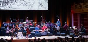 The Silkroad Ensemble performs in front of an audience in a mix of different cultural attire and instruments.
