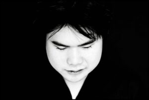 A black-and-white image of Nobuyuki Tsujii looking down with his eyes closed.