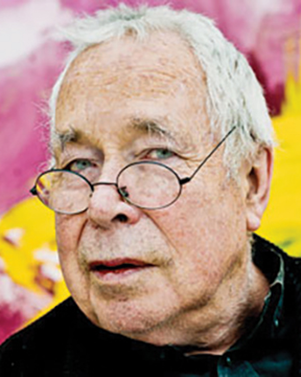 A portrait image of artist Howard Hodgkin, an older man with white hair and round glasses.