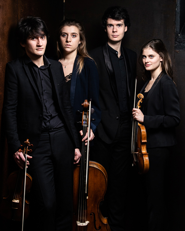 The Le Consort group standing next to each other holding their string instruments wearing black formal dress.
