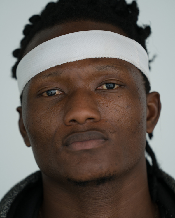 A close up photo of artist Pacome Landry Seka wearing a white headband across his forehead.