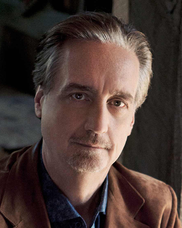 A headshot image of David Finckel, a white man with light brown hair, wearing a brown suit looking into the camera.