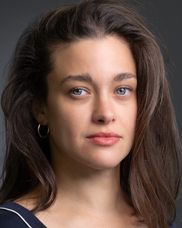 Iyar Elezra, a light olive-skinned woman with long brown hair and blue eyes, looks into the camera