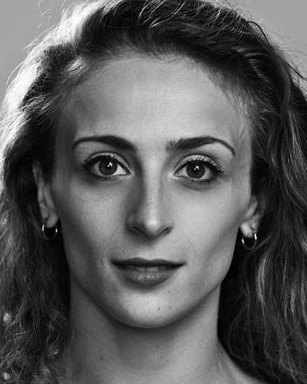 A black-and-white headshot image of Marzia Memoli, a fair-skinned woman with long wavy hair, looking into the camera.