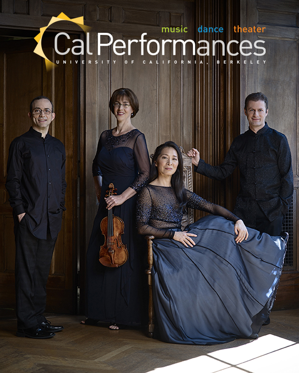 The Brentano String quartet, two men and two women in formal attire, pose with the two women in the center, one seated, and the men standing at the ends