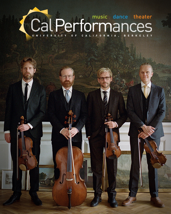 The four men of the Danish String stand next to each other holding their instruments, dressed in suits and ties.