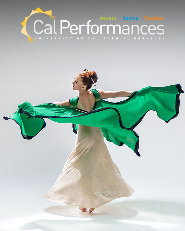 A dancer of the Martha Graham Dance Company in a flowy white dress throwing up her green cape.