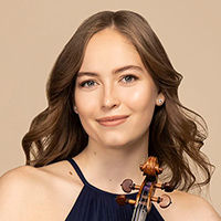 Geneva Lewis, a young woman with long curled brown hair wearing a navy blue dress, smiles as she poses with her violin in hand.