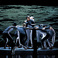A male and female dancer from the Mark Morris Dance Group practicing a partner lift in the rehearsal room.