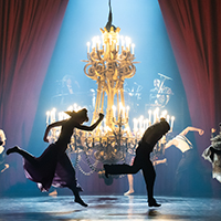Dancers of the Paris Opera Ballet performing on a dimly lit stage like they're partying.