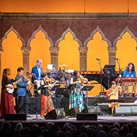 The Silkroad Ensemble performs in front of an audience in a mix of different cultural attire and instruments.